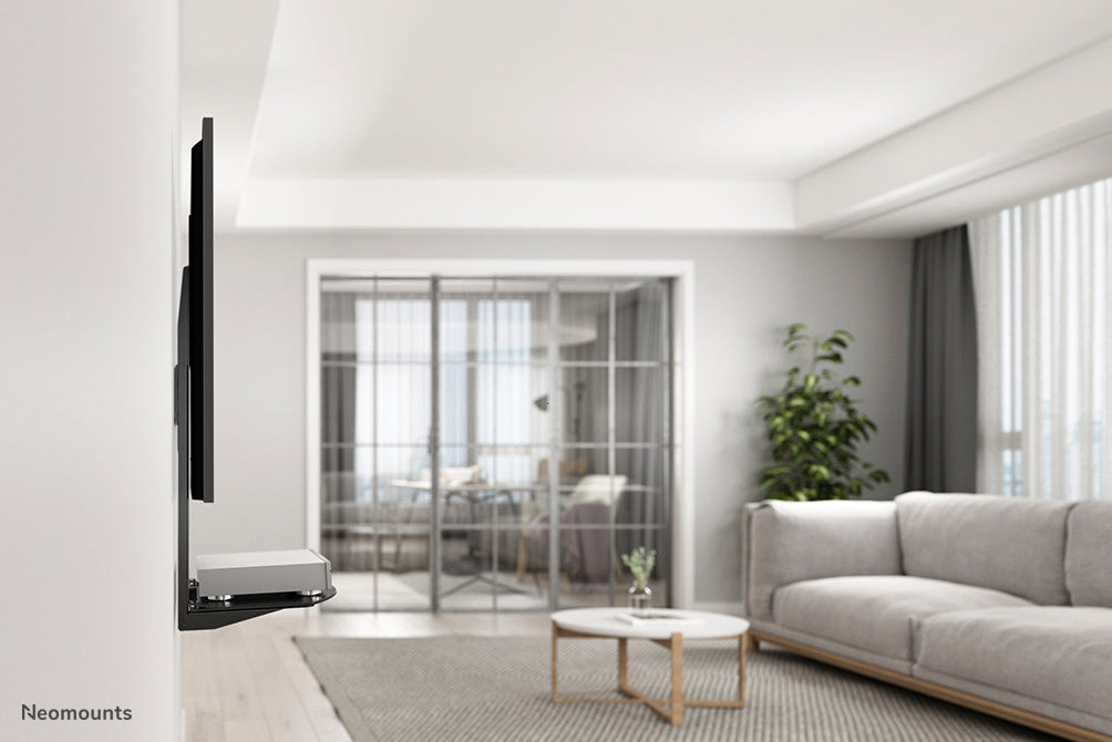 Neomounts AV-holder, model NS-SHELF100, er ideel til placering af AV-udstyr under fladskærmholdere.